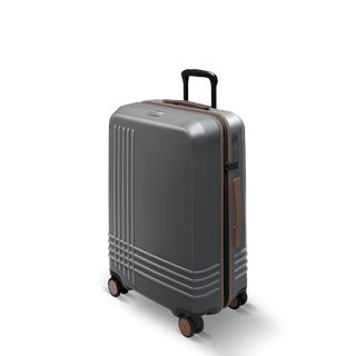 ROAM Matte Edit hardside check-in suitcase in matte steel with saddle trim, three-quarter view