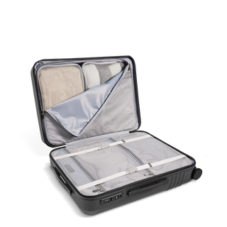 ROAM Matte Edit hardside expandable carry-on suitcase in matte steel, open, showing the packed interior