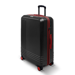 ROAM Matte Edit hardside large check-in suitcase in matte black with red trim, three-quarter view