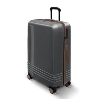 ROAM Matte Edit hardside large check-in suitcase in matte steel with saddle trim, three-quarter view