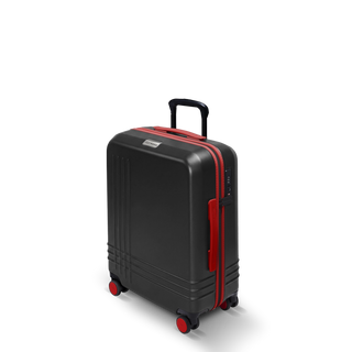 ROAM Matte Edit hardside large carry-on suitcase in matte black with red trim, three-quarter view